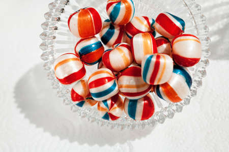 colorful candies in a glass bowl on the white backgroundl, note shallow depth of field