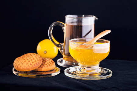 linden tea with  honey, lemon and gingerbread on the black backgroundの写真素材