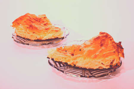 two piece of pie with cheese on a two plate and a white backgroundの写真素材