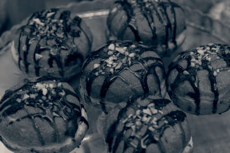 donuts topped with jam on a glass plate, note shallow depth of field