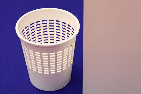 white plastic wastebasket on blue floorの写真素材