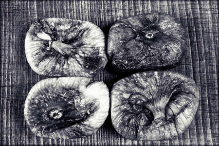 dried figs on a wooden table, note shallow depth of field