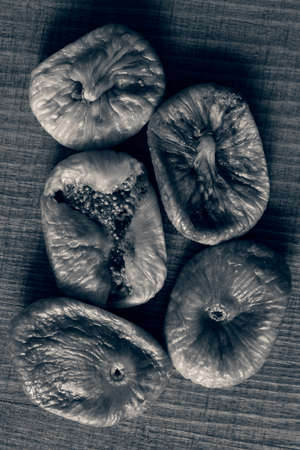 Dried figs on a wooden table, note shallow depth of fieldの写真素材