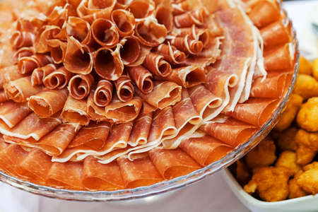 prosciutto as an appetizer served on a round plateの写真素材