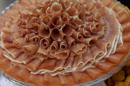 prosciutto as an appetizer served on a round plateの写真素材