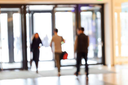 silhouettes of people as they move through the mal with light backgroundl, for the bluured...