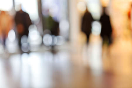 silhouettes of people as they move through the mal with light backgroundl, for the bluured...