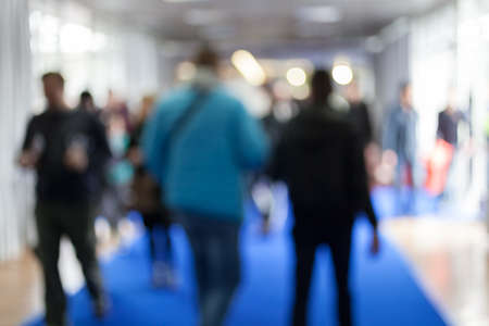 Silhouettes of people as they move along the blue carpet in malll, for the bluured backgroundの写真素材