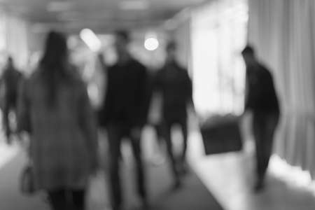 Silhouettes of people as they move along the blue carpet in malll, for the bluured backgroundの写真素材