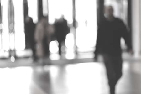 silhouettes of people as they move through the mal with light backgroundl, for the bluured backgroundの写真素材