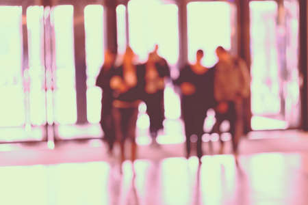 silhouettes of people as they move through the mal with light backgroundl, for the bluured backgroundの写真素材