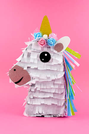 Handmade colorful Unicorn PiÃ±ata on pink backgroundの写真素材
