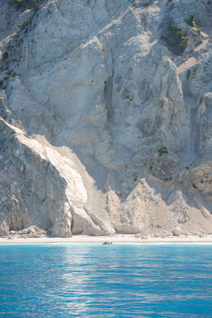 Beautiful wild Mediterranean pebble beach under a large massive rockの写真素材