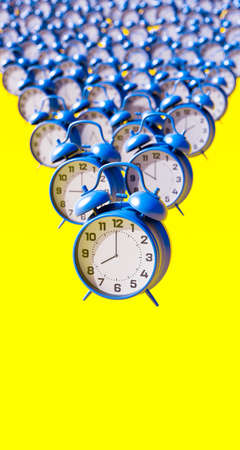 Blue alarm clocks on vibrant yellow background vertical composition 3d render 3d illustration