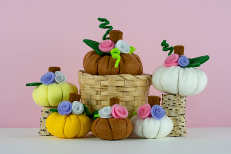 Handmade cute pumpkins made from felt on pink backgroundの写真素材