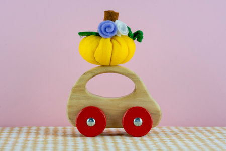 Handmade pumpkin made from felt on cute wooden toy carの写真素材