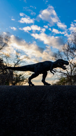 T Rex Dinosaur monstrous animal with sharp teeth standing on the concrete wallの写真素材