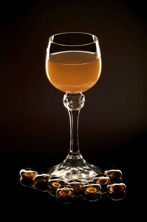 Photoillustration of a glass of amber nectar isolated on blackの写真素材