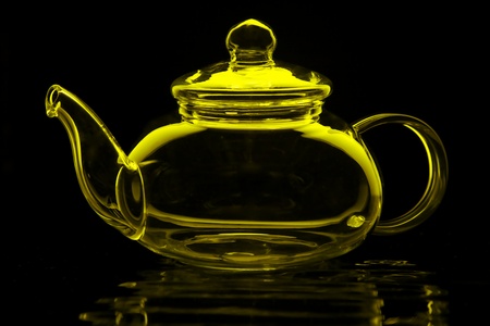 Glass teapot in lime green isolated on blackの写真素材