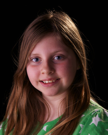 young girl wearing green top on black backgroundの写真素材