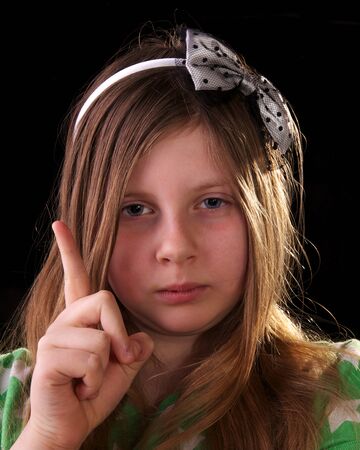 Young girl scolding and shaking her finger on blackの写真素材
