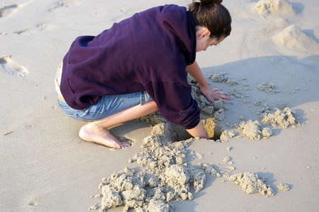 girl digs in the sandの写真素材