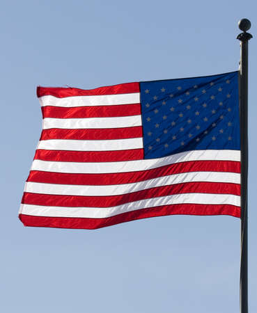 Waving american flag over a blue sky