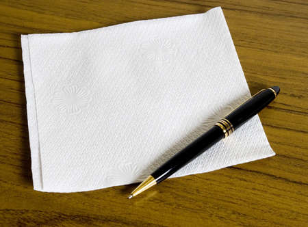 Blank napkin for your message on wooden table and a penの写真素材