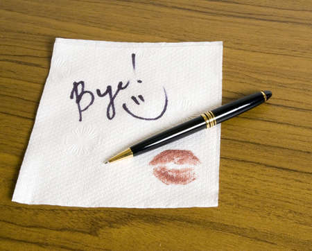 Word Bye and a smiley face on the napkin (with pen)の写真素材