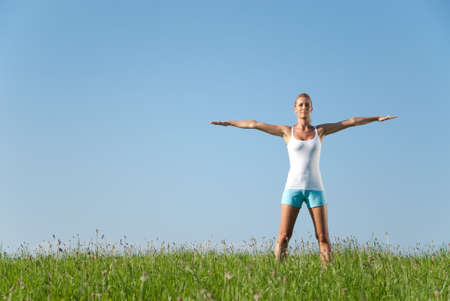 Young woman is doing fitness exercise in the natureの写真素材