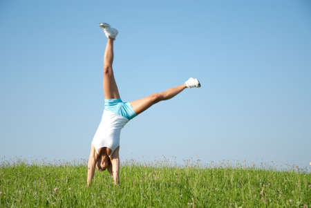 Young woman is doing fitness exercise in the natureの写真素材