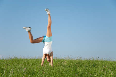 Young woman is doing fitness exercise in the natureの写真素材