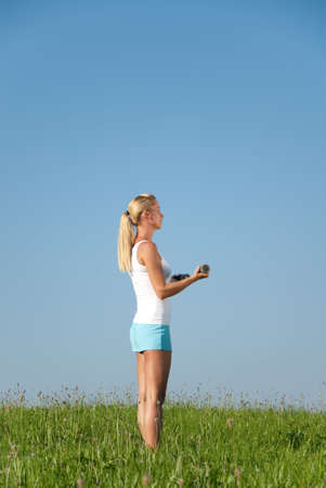 Young woman is doing fitness exercise in the natureの写真素材