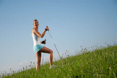 young goes woman nordic walking in her spare time in the natureの写真素材