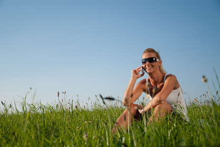 young woman communicates by phone outdoorsの写真素材