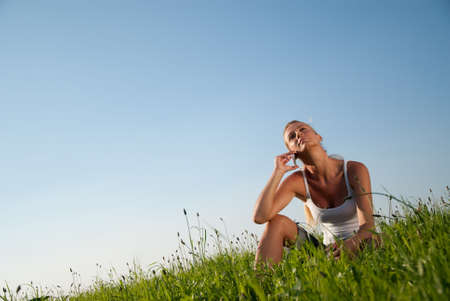 young woman communicates by phone outdoorsの写真素材