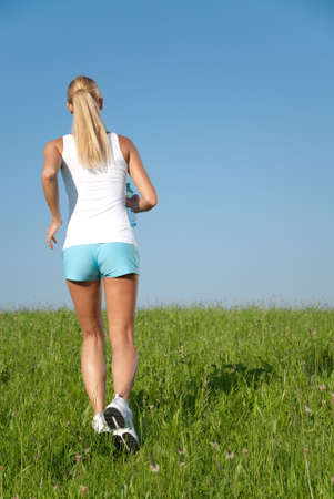 Young woman is doing fitness exercise in the natureの写真素材