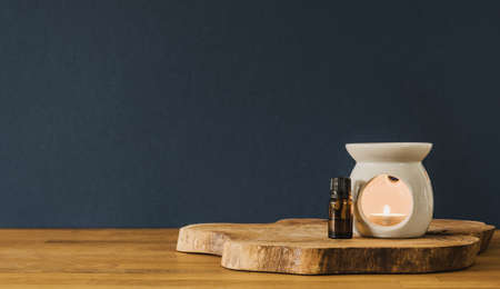 Glass bottle and candle on wooden desk with copy spaceの写真素材