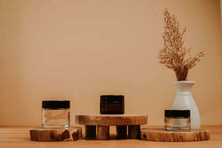 Jar set on wooden stage and brown natural leaf in vase