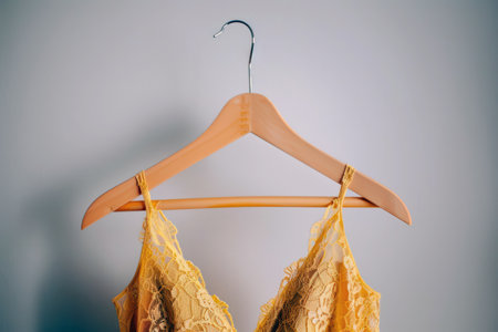 Yellow lace summer dress on hanger against stylish backgroundの素材