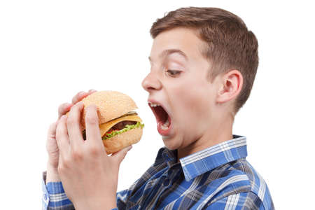 Hungry teenager wants to eat a big juicy burgerの写真素材