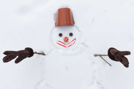 new year snowman instead of hands with gloves and a flower pot on the headの写真素材