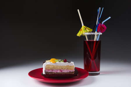 Tasty cake with fruit on a plate and cocktail