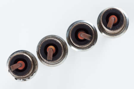 Close-up four old burned spark plugs for gasoline-powered carsの写真素材
