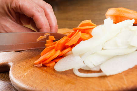 sliced onion and carrot on chopping board for cooking