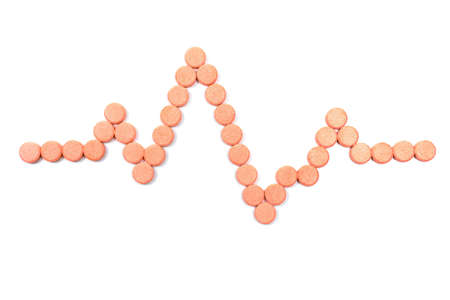 Stack of pills in the form of a cardiogram isolated on white backgroundの写真素材