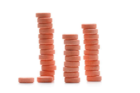 Pink stack of pills isolated on white backgroundの写真素材