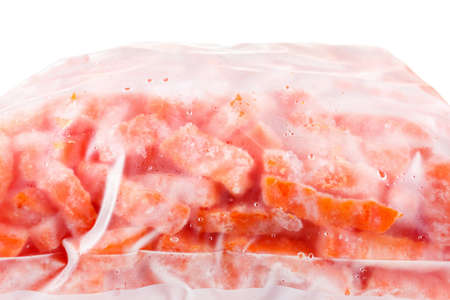 Group of sliced frozen carrots in a plastic bag, isolated on whiteの写真素材