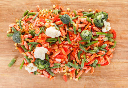 Background collection of frozen fresh vegetables for cooking on cutting boardの写真素材