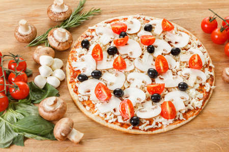 Food ingredients for pizza on table close up. Cooking homemade pizza with fresh vegetables and olivesの写真素材